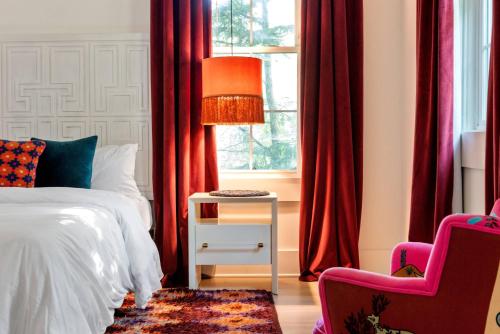 a bedroom with red curtains and a bed and a chair at Mystique in Atlanta