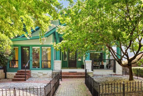 a green house with a tree in front of it at Mystique in Atlanta