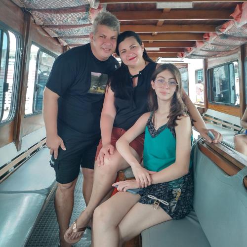 a group of three people sitting on a train at Mini casa (kit net) in Florianópolis