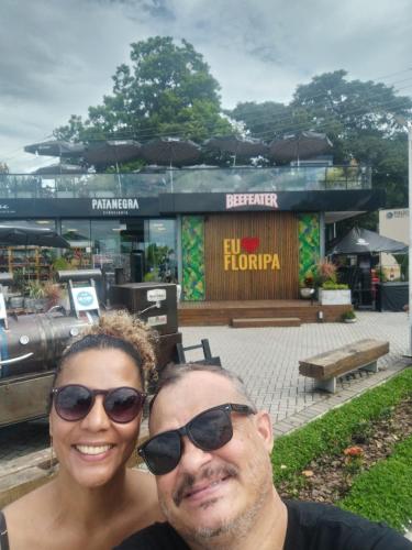 a man and a woman standing in front of a store at Mini casa (kit net) in Florianópolis