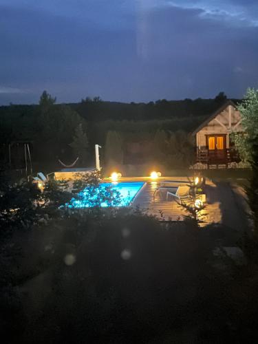 a pool with lights in a yard at night at Osada Turystyczna Miłoszówka in Wąwolnica