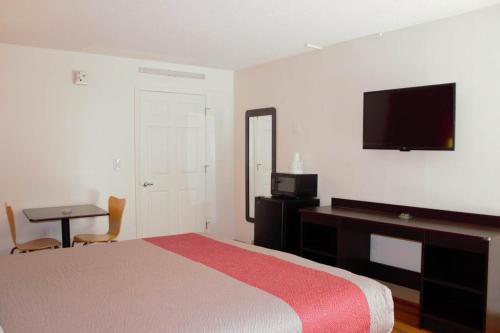 Un dormitorio con una cama, un escritorio y un televisor. en Motel 6-Cleveland, TN, en Cleveland