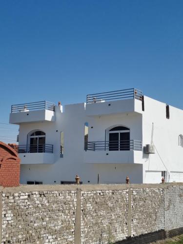 Al KarnakにあるVilla Saeedの白い建物(バルコニー付)と石壁