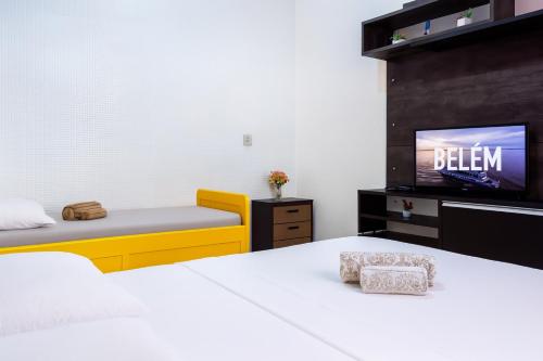 a bedroom with two beds and a tv on a wall at Para Temporada in Belém