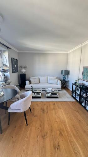 a living room with a white couch and wooden floors at Exklusive 60qm Designerwohnung im Herzen von München - 1 min zur Maximilianstraße in Munich