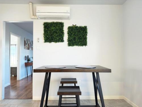 a table with a chair next to a wall with green plants at Harrison Ranchhr4 in Visalia