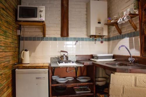 a small kitchen with a sink and a microwave at Posada de Nono in Nono