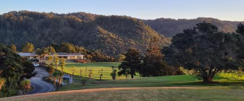 a house on a hill next to a road at Waitakere Resort & Spa in Auckland