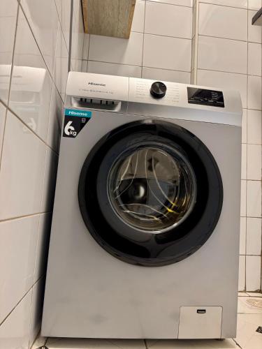 a white washing machine in a corner of a kitchen at Lipsy Homes Kungu in Kampala