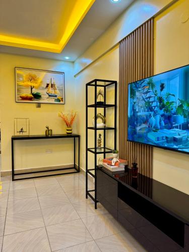 a living room with a large flat screen tv at Lipsy Homes Kungu in Kampala