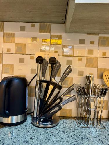 a kitchen counter with a coffee maker and utensils at Lipsy Homes Kungu in Kampala
