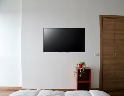 a living room with a television on a white wall at New Residence Emilia in San Donato Milanese