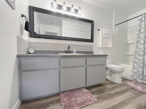 a bathroom with a sink and a toilet and a mirror at Lovely Home Central Coalinga in Coalinga