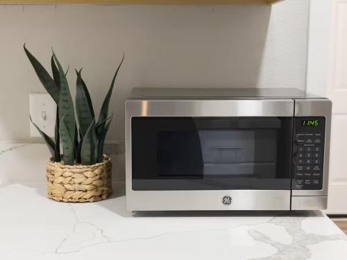 a microwave sitting on a counter next to a plant at Ocean Breeze Harrison Ranch 2 in Visalia