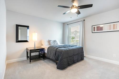 a bedroom with a bed and a ceiling fan at New Charming Surburban Retreat 12 mins to Lakepoint in Acworth