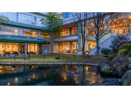 a building with a pond in front of it at Hotel Symphony - Vacation STAY 85393v in Sagae