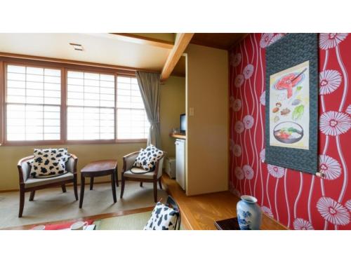 a living room with two chairs and a painting on the wall at Hotel Symphony - Vacation STAY 85393v in Sagae