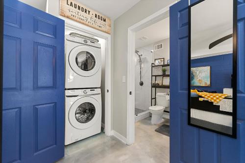 a bathroom with a washing machine and a blue door at The Rhitreat, Studio, 10 Min Downtown & Airport in Atlanta