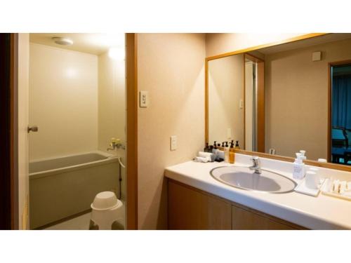 a bathroom with a sink and a large mirror at Hotel Symphony - Vacation STAY 85394v in Sagae
