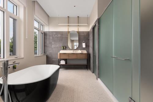 a bathroom with a tub and a sink at Hotel Railwayparc Montreal, Tapestry Collection By Hilton in Montréal