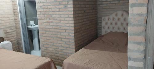 Schlafzimmer mit Ziegelwand und Bett in der Unterkunft Villa Fernandito in Fernando de la Mora