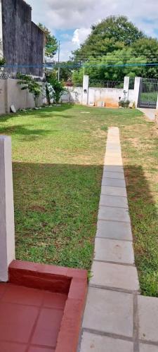 a walkway in a yard next to a grass field at Villa Fernandito in Fernando de la Mora