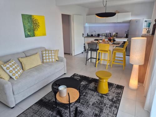 a living room with a couch and a kitchen at AQUAWAVES - Appartement T2 CARLA SUN - Saint-François in Saint-François