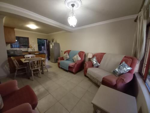 a living room with two couches and a kitchen at 110 Bay View in Brenton-on-Sea