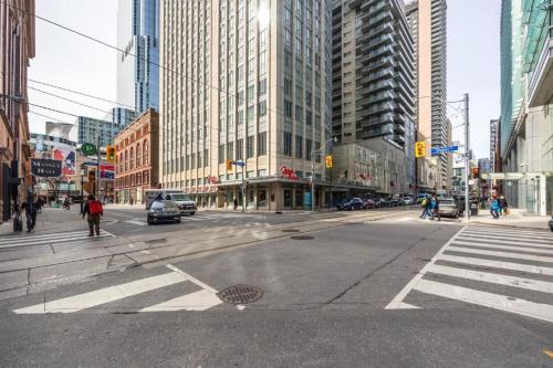 an empty street in a city with tall buildings at High Rise 2BR Contemporary Condo w City Views next to Eaton Centre in Toronto