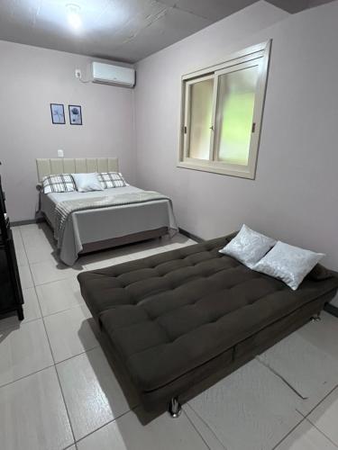 a bedroom with a large bed and a window at Casa no Vale dos Vinhedos in Bento Gonçalves