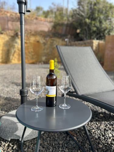 a bottle of wine and two wine glasses on a table at Casa Noroeste in Puntagorda