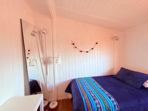 a bedroom with a bed with a blue comforter at MAKTVB - EcoLodge San Pedro de Atacama in San Pedro de Atacama