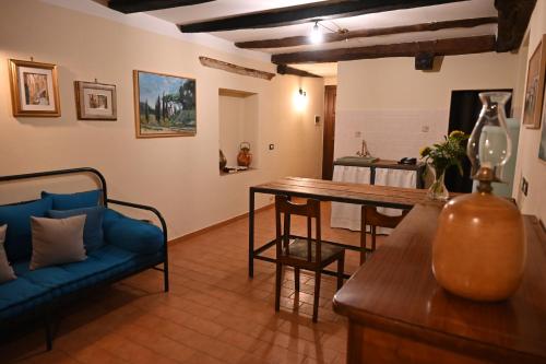 a living room with a blue couch and a table at il Cantuccio in Pitigliano