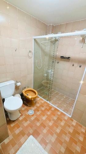 a bathroom with a toilet and a glass shower at Cobertura Aconchegante na Enseada 3 Quartos, Piscina e Conforto a Poucos Passos do Mar in Guarujá