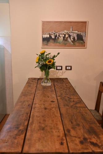 a vase of flowers sitting on top of a wooden table at il Cantuccio in Pitigliano
