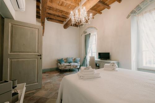 Un dormitorio con una cama, una silla y una lámpara de araña. en Dimora Lucia - Camere Relax con bagno privato, en Fossombrone