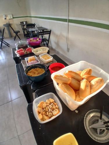 a buffet line with bowls of food on a table at Pousada Imperial in Itaboraí
