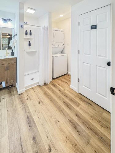 a bathroom with wooden floors and a white door at 1 BR Fire Pit BBQ Retreat in Evansville