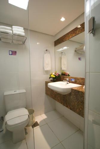 a bathroom with a toilet and a sink at Hotel Diogo in Fortaleza