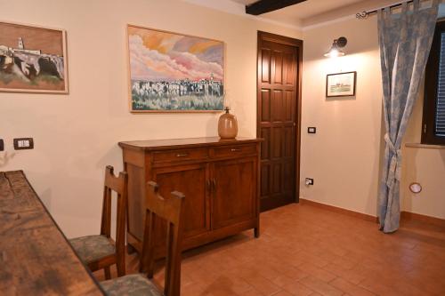 a living room with a wooden cabinet and a table at il Cantuccio in Pitigliano