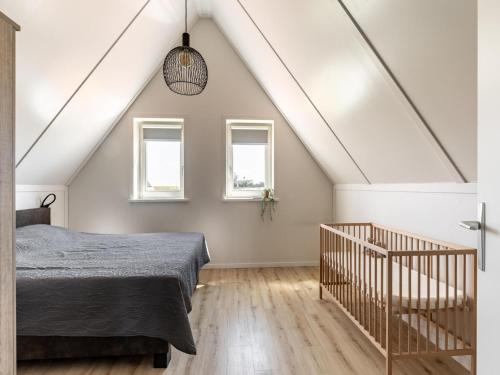 Un dormitorio con una cama y dos ventanas. en Holiday Home in Scherpenisse near Oosterschelde, en Scherpenisse