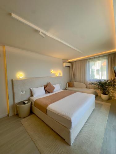 a bedroom with a large bed and a couch at Mamaia Moments Villa, Mamaia Nord in Mamaia Sat/Năvodari