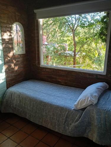 a bed in a room with a large window at Posada de Nono in Nono