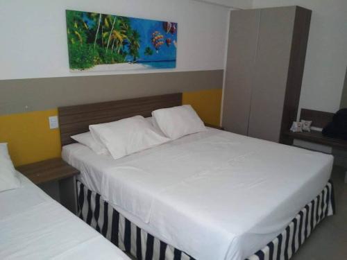 twee bedden in een hotelkamer met twee witte bedden bij Apartamento dentro de um Resort 6 in Olímpia
