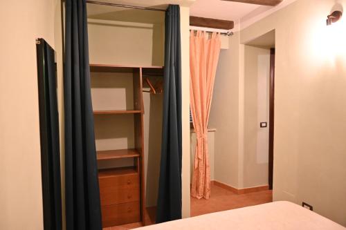 a bedroom with a bed and a closet with a mirror at il Cantuccio in Pitigliano