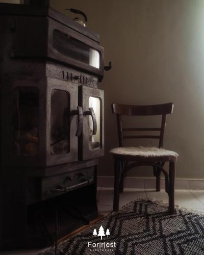 a chair in a room with a stove and a chair at Forrest Guesthouse in Polídhroson