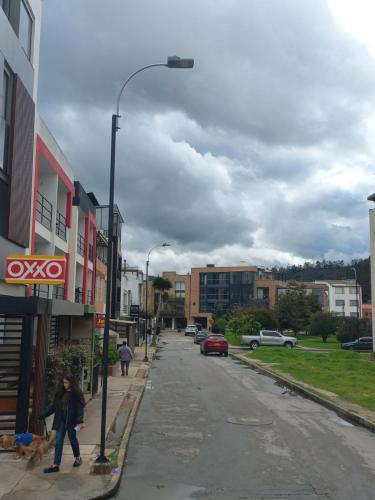 a person walking a dog on a city street at Acogedor Apto Junto al Parque in Tunja