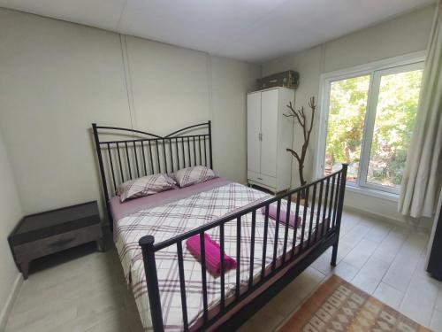 a bedroom with a bed and a window at Gelidonia Fenerium Holiday Home in Antalya