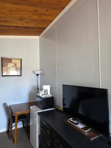 a room with a desk with a television and a table at Bio Vista Motel in Wainwright