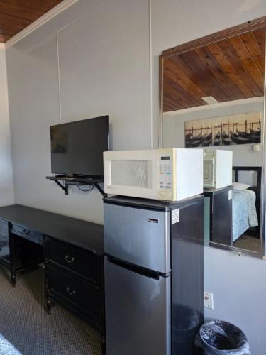a microwave on top of a refrigerator in a room at Bio Vista Motel in Wainwright